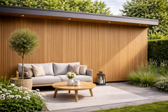 Tuinhuis met verticale ayous gevelbekleding in Thermowood naast een loungeset op een terras