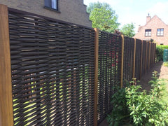 Lange rij Forest Avenue fiber gevlochten tuinschermen met houten tussenpalen, geplaatst als duurzame erfafscheiding in een woonwijk.