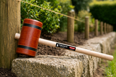 Tuinhamer van hout in actie bij het inslaan van een paal, ideaal voor kastanje palen en omheiningen